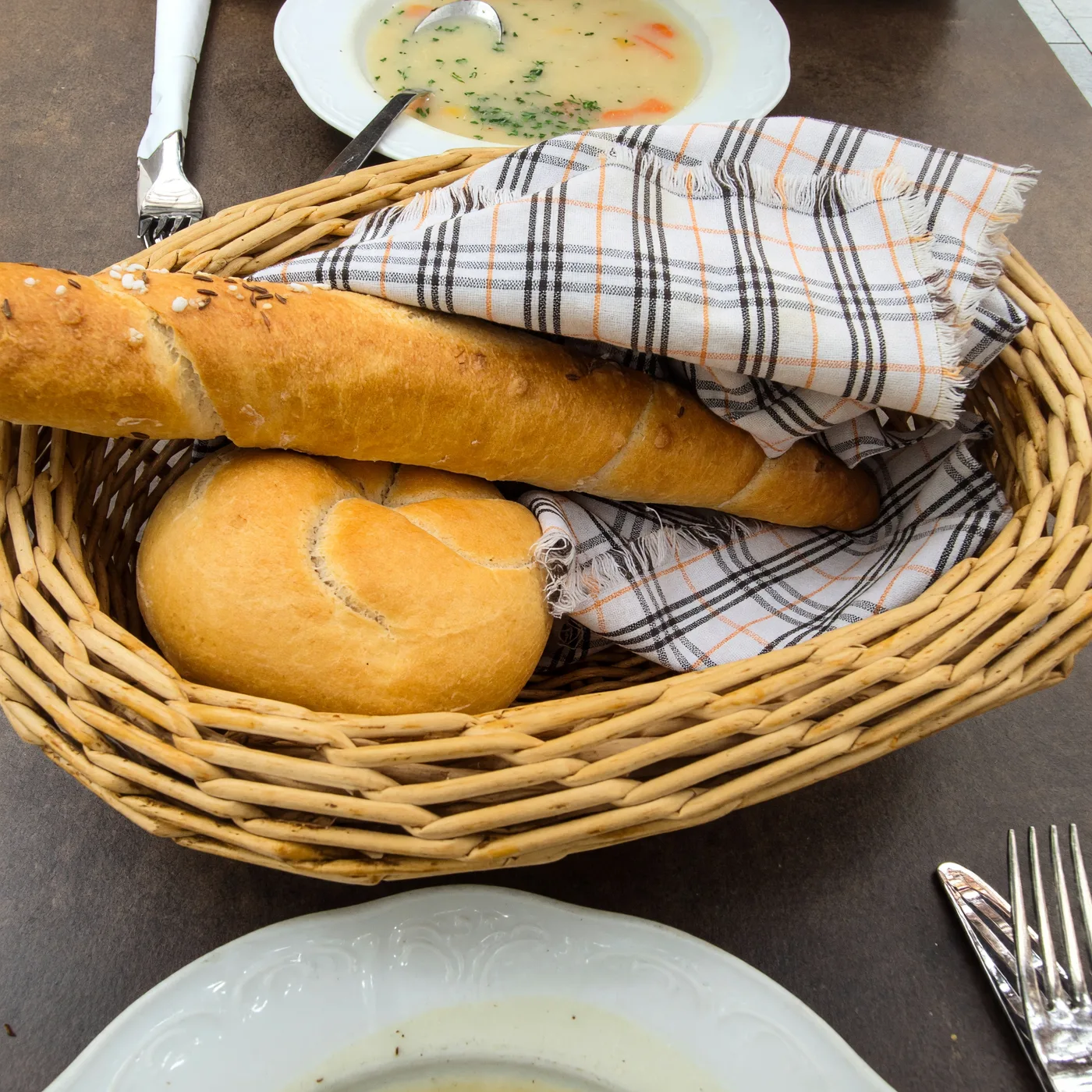 Brotkorb mit Salzstangerl und Semmel, fotografiert von einem Gast