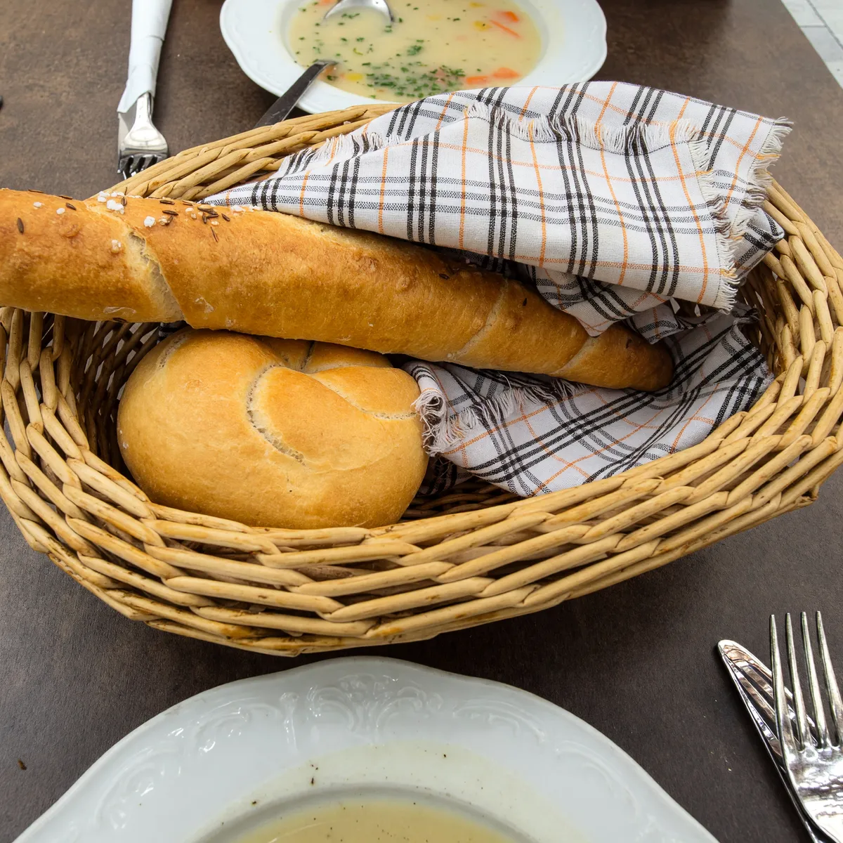 Brotkorb mit Salzstangerl und Semmel auf einem Tisch im Innenhof